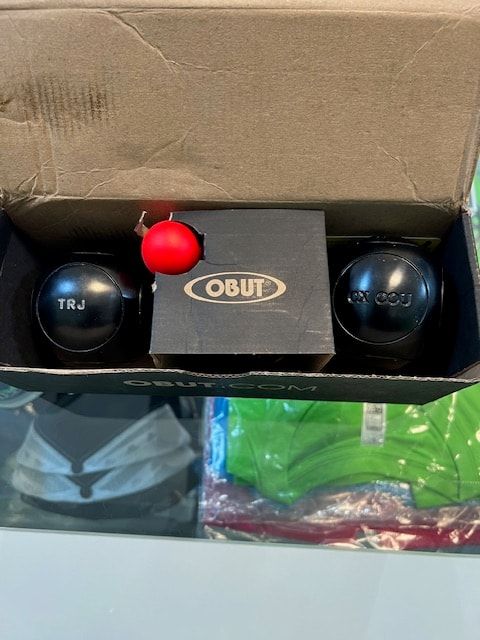 Boîte Obut ouverte avec deux boules noires gravées et un cochonnet rouge