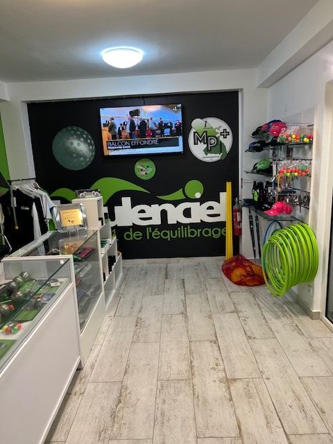 Intérieur de la boutique MP+ : vitrines, mur noir Boulenciel, logo MP+ et cercles d'entraînement verts
